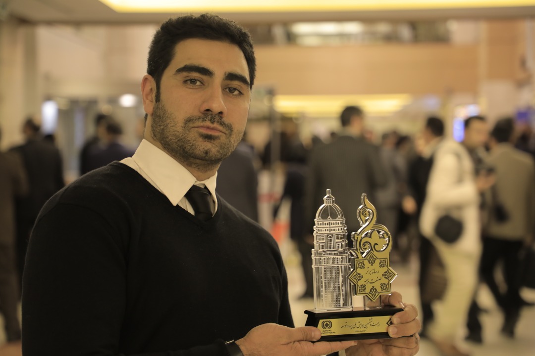 Ashkan Izadi holding an award from the insurance IT industry
